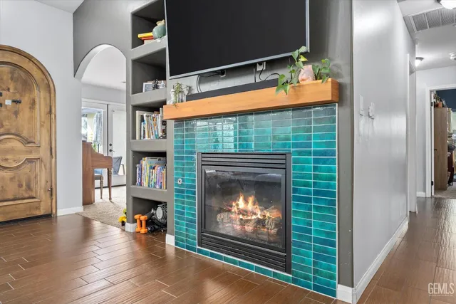 a view of an empty room with a fireplace and a flat screen tv