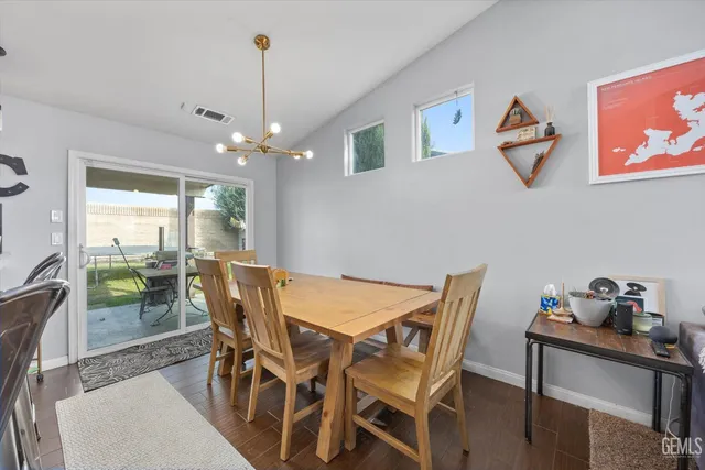 a kitchen with stainless steel appliances granite countertop sink wooden floor dining table and chairs