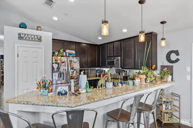 a kitchen with stainless steel appliances granite countertop a sink a stove and a refrigerator