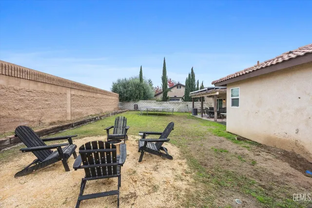 a couple of blue chairs sitting on sand and a bench