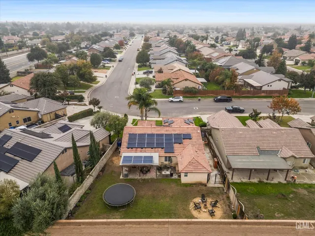 a front view of a house with a garden and palm trees