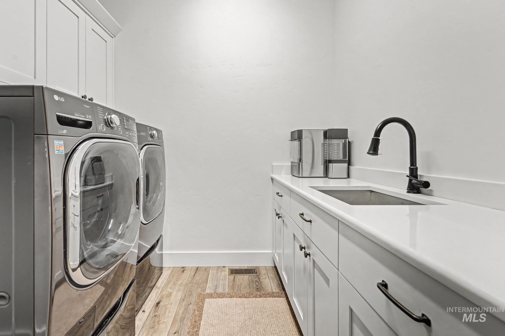 18357 North Burnt Car Way Boise, ID 83714 - Photo 43 of 48 Laundry area featuring cabinet space, washer and dryer, and light wood-style floors