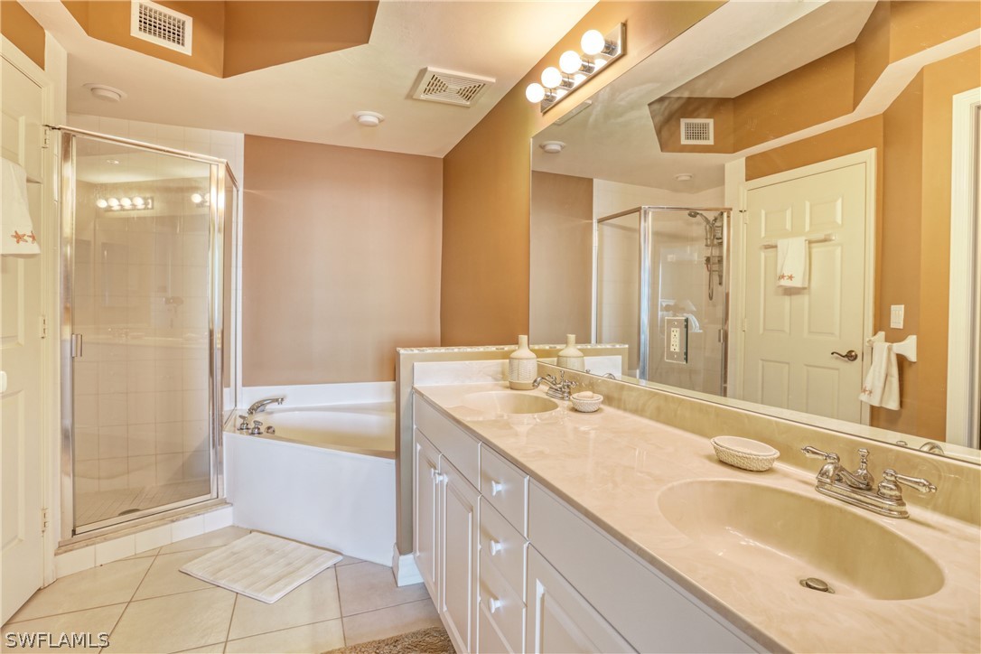 2797 First Street, Unit 1802 Fort Myers, FL 33916 - Photo 19 of 32 a bathroom with a granite countertop sink a mirror a bathtub and shower