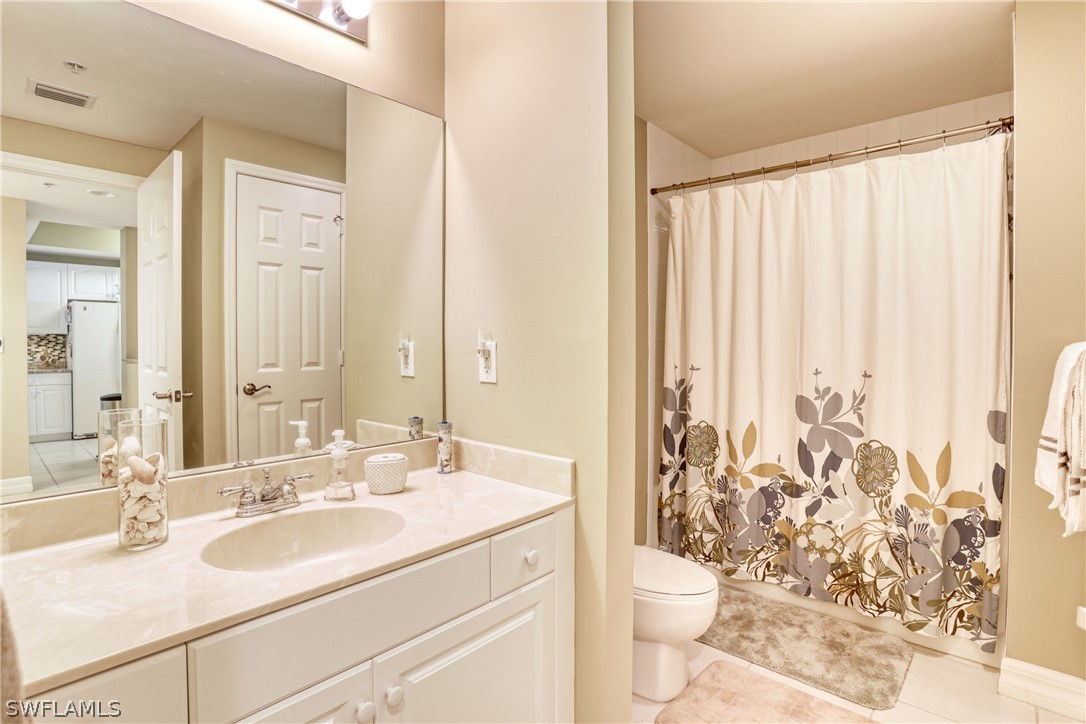 2797 First Street, Unit 1802 Fort Myers, FL 33916 - Photo 22 of 32 a bathroom with a sink a toilet and a mirror