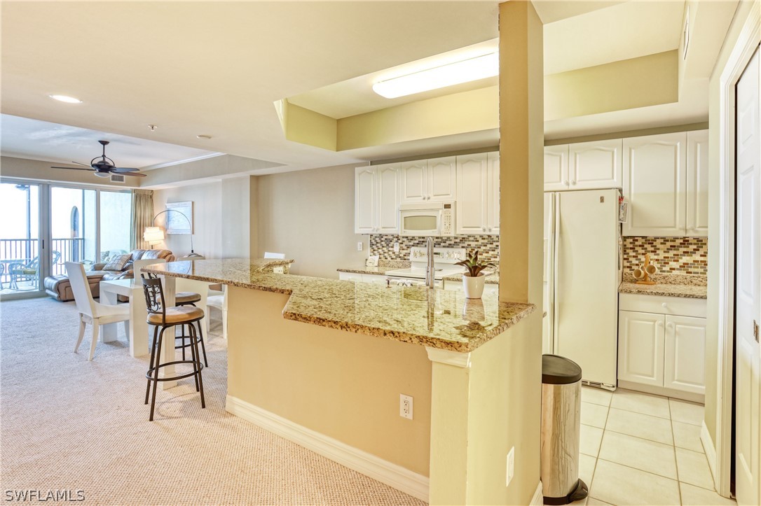 2797 First Street, Unit 1802 Fort Myers, FL 33916 - Photo 4 of 32 a dining hall with stainless steel appliances kitchen island granite countertop a table and chairs in it
