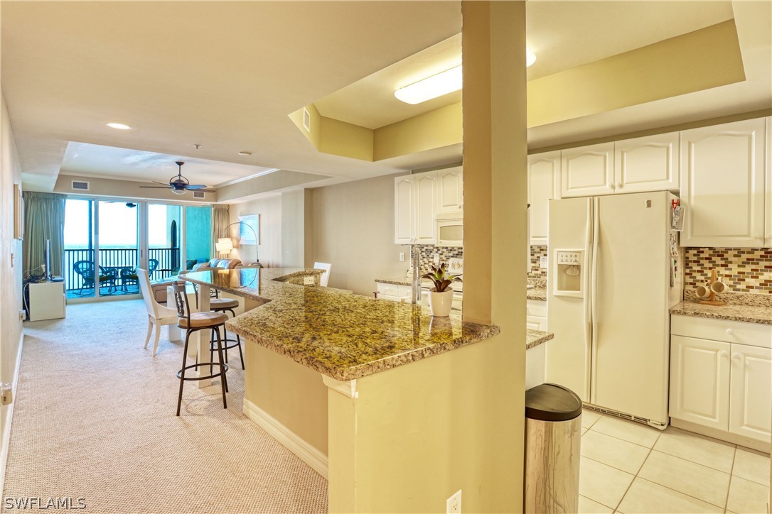 2797 First Street, Unit 1802 Fort Myers, FL 33916 - Photo 5 of 32 a kitchen with a refrigerator and table