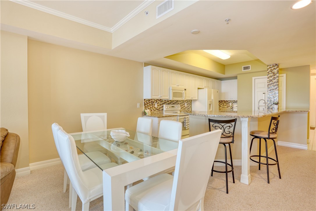 2797 First Street, Unit 1802 Fort Myers, FL 33916 - Photo 9 of 32 a dining room with furniture and a floor to ceiling window