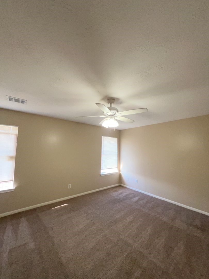 16410 Amy Ridge Road Houston, TX 77053 - Photo 5 of 17 an empty room with a chandelier fan and windows