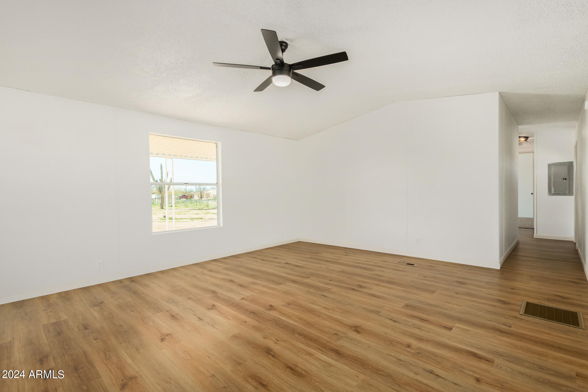 355 North Conejo Road Maricopa, AZ 85139 - Photo 7 of 30 an empty room with wooden floor fan and windows