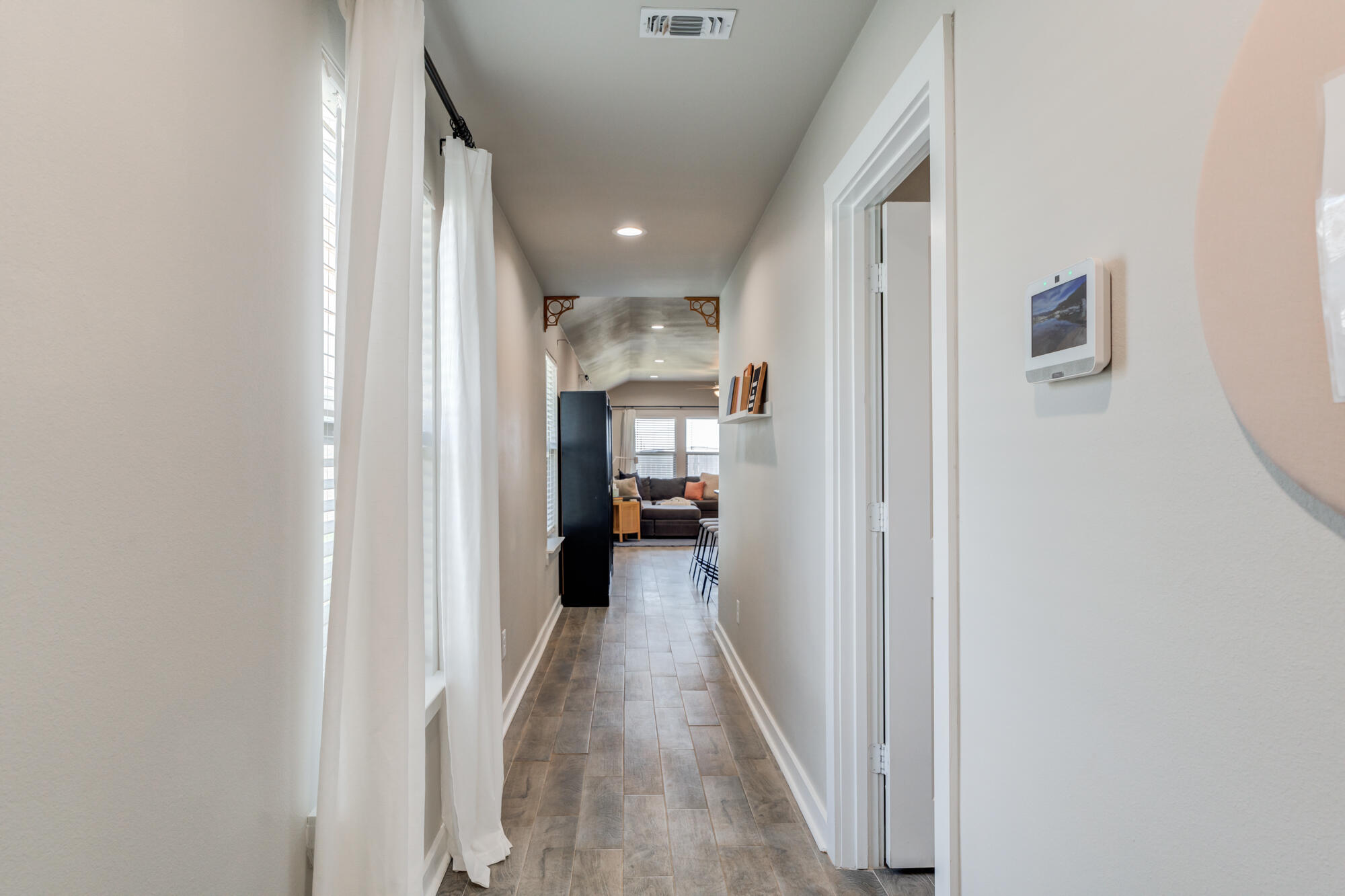 4613 126th Street Lubbock, TX 79424 - Photo 12 of 37 a view of a hallway with a livingroom and a bathroom with sink