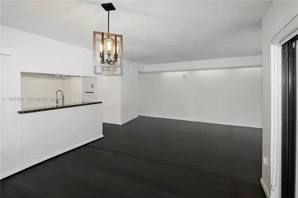 a view of an empty room with wooden floor and windows