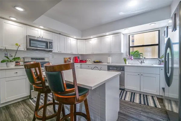 a kitchen with a dining table chairs and microwave