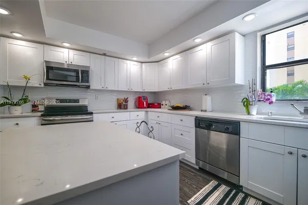 a kitchen with stainless steel appliances a microwave sink refrigerator and cabinets
