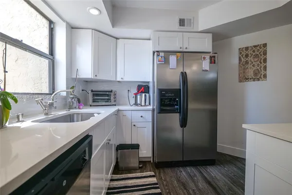 a kitchen with stainless steel appliances granite countertop a refrigerator a sink dishwasher a stove with wooden floor