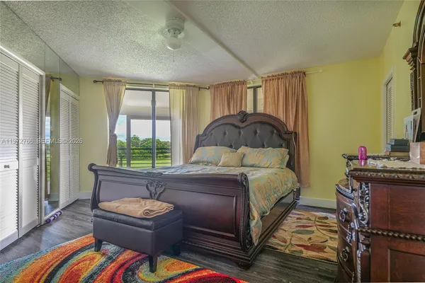 a bedroom with a bed and a dresser next to a window