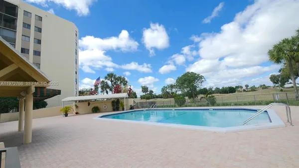 a view of swimming pool with seating yard and mountain view in back
