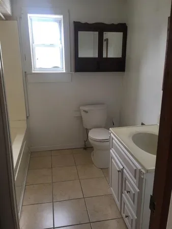 a white house sitting on the side of a yard