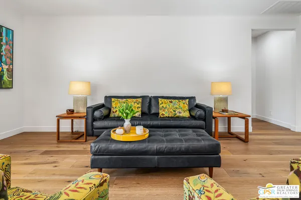 a living room with furniture and a wooden floor