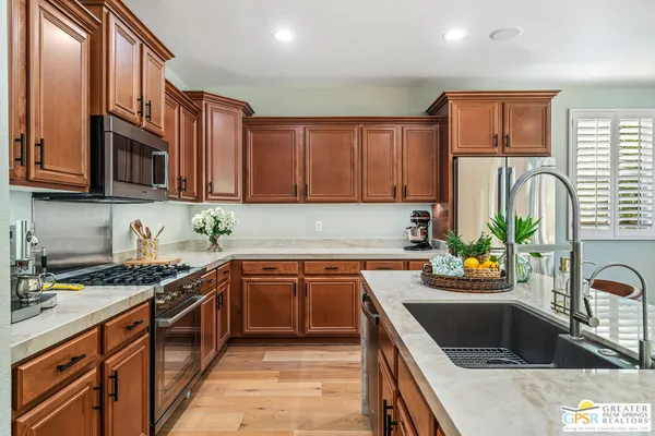 a kitchen with stainless steel appliances a stove a microwave cabinets and a counter top space