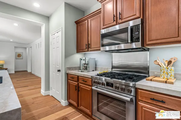 a kitchen with stainless steel appliances granite countertop a stove and a dining table