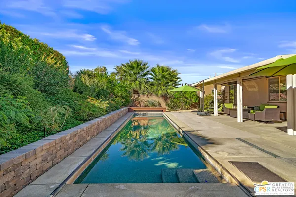 a view of a house with backyard sitting area and garden