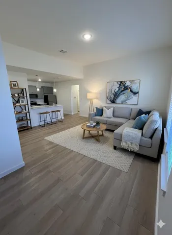 a living room with furniture and a wooden floor