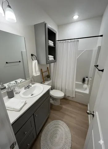 a bathroom with a sink a toilet and shower