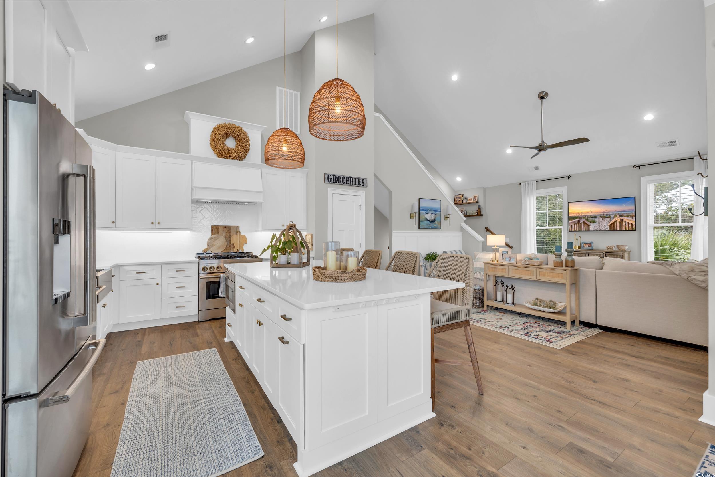 22 Trigger Fish Lane Murrells Inlet, SC 29576 - Photo 11 of 39 Kitchen with high end appliances, a kitchen breakfast bar, decorative light fixtures, a kitchen island, and white cabinetry