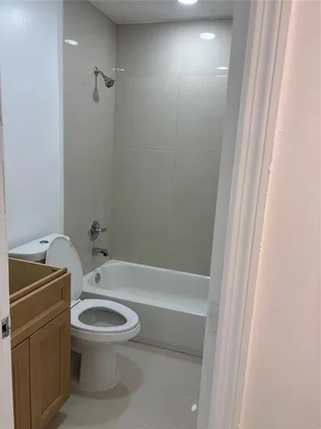 a white toilet sitting next to a bathroom sink and tub