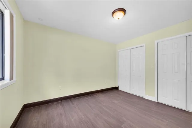 a view of a room with wooden floor and a window