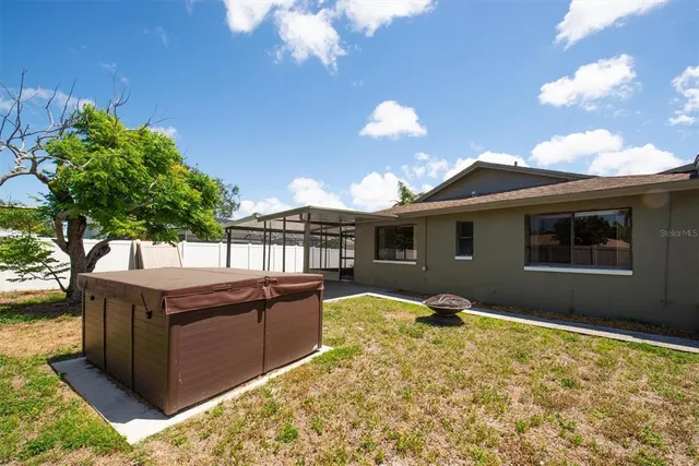 a view of a house with backyard and sitting area