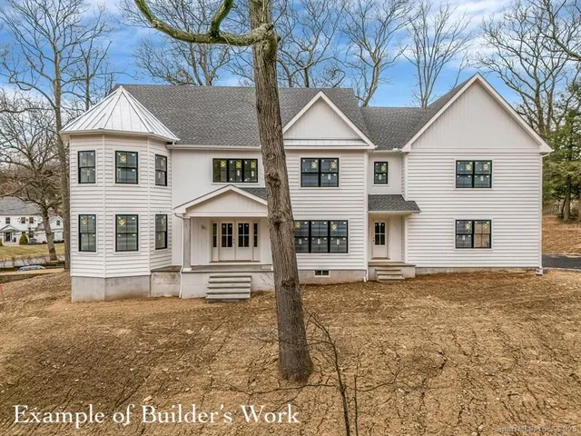 a view of a white house with large trees