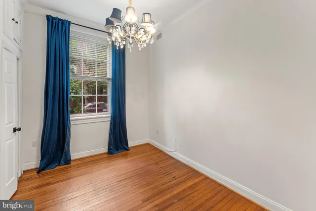 a view of a room with wooden floor and chandelier