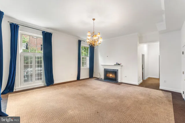 a view of an empty room with a fireplace and a window