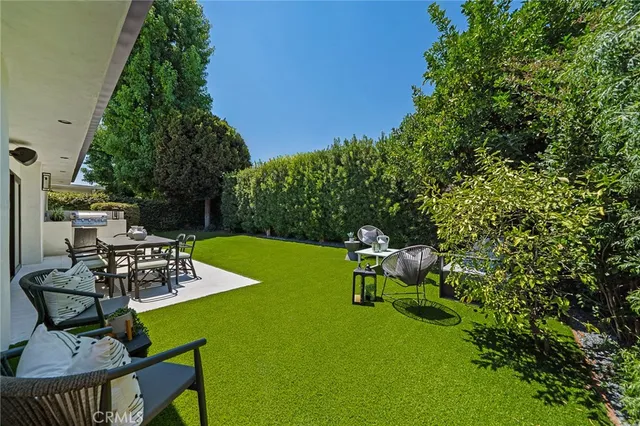 a view of a backyard with table and chairs and potted plants
