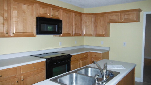 640 Lokchapee Ridge Macon, GA 31210 - Photo 19 of 22 a kitchen with granite countertop a sink a stove and cabinets