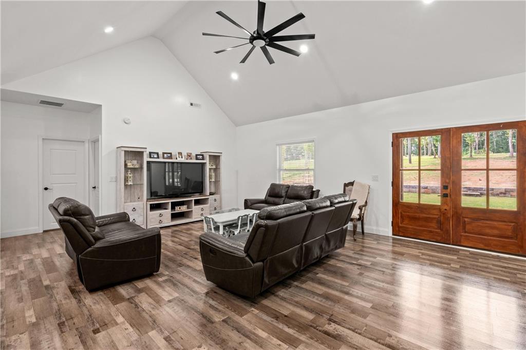 1175 Burwell Mt Zion Road Carrollton, GA 30117 - Photo 9 of 29 a living room with furniture a flat screen tv and a floor to ceiling window