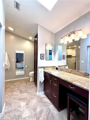 a spacious bathroom with a granite countertop sink and a mirror