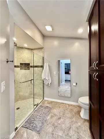 a bathroom with a granite countertop sink a toilet and shower