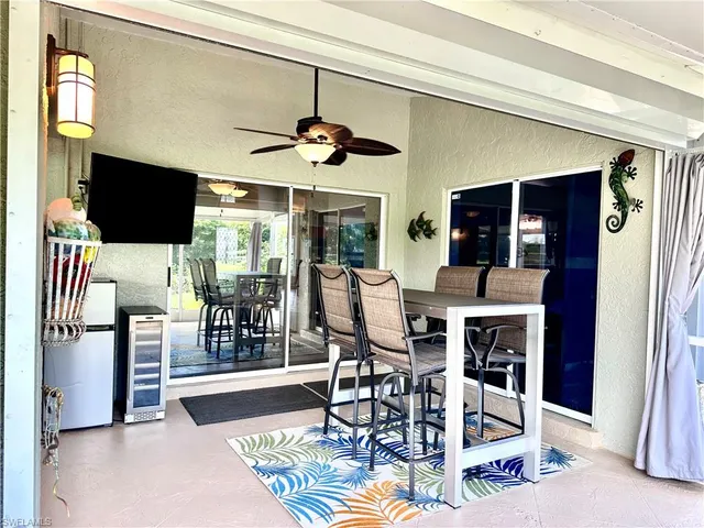 a view of a patio with couches table and chairs potted plants and palm tree