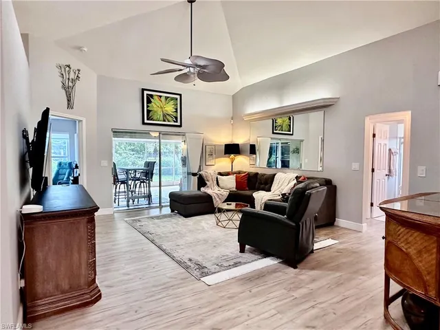 a living room with furniture a chandelier and a flat screen tv