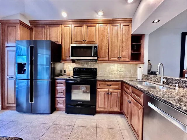 a kitchen with stainless steel appliances granite countertop a refrigerator and a sink