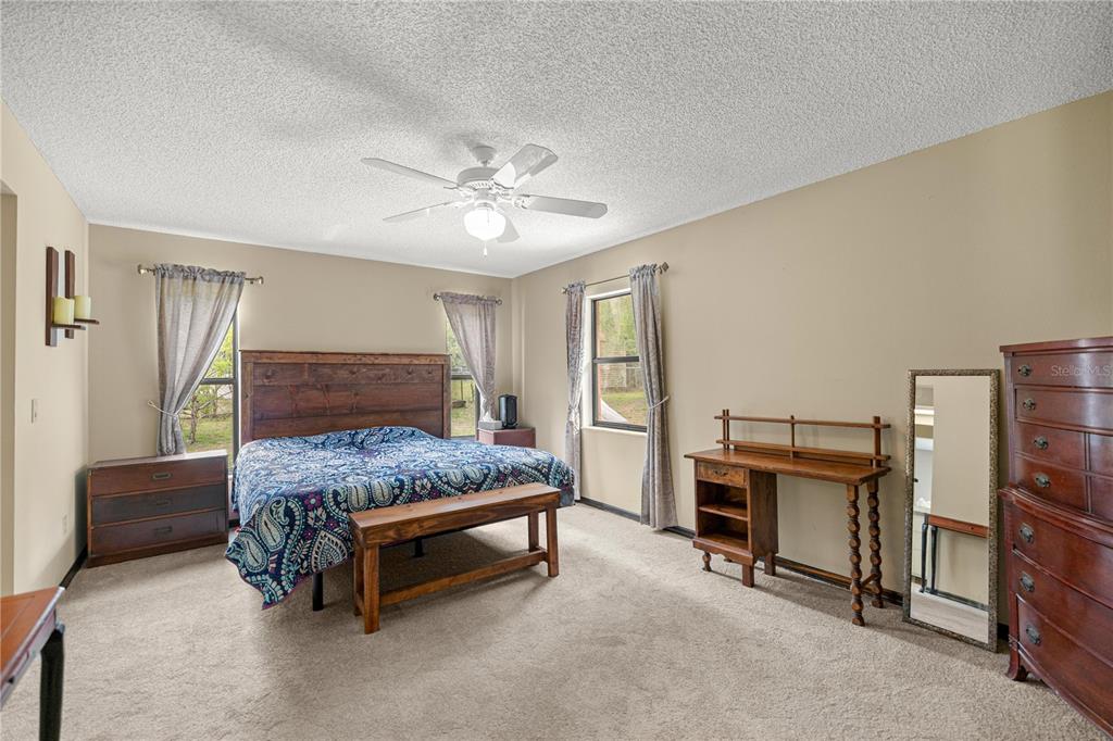 761 South Jeanne Avenue Inverness, FL 34453 - Photo 12 of 33 a bedroom with a bed and a chandelier