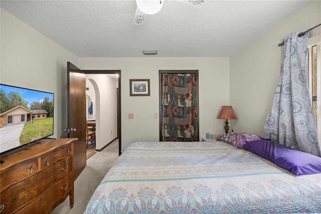 761 South Jeanne Avenue Inverness, FL 34453 - Photo 17 of 33 a spacious bedroom with a bed and a flat screen tv