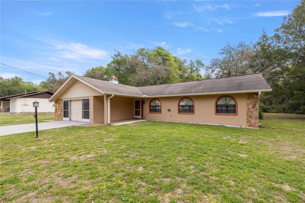 761 South Jeanne Avenue Inverness, FL 34453 - Photo 22 of 33 a house with green field in front of it