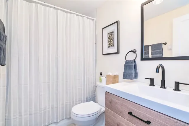 a bathroom with a toilet a sink and mirror