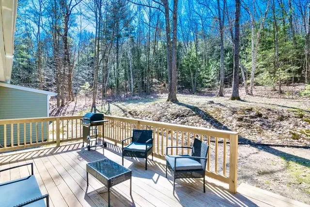 a view of a wooden chairs and deck in the backyard