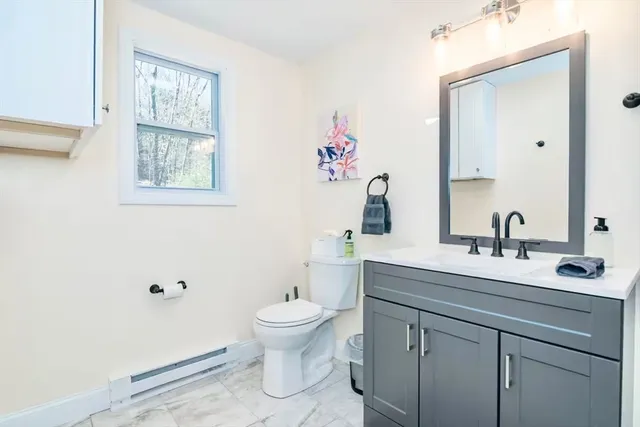 a bathroom with a toilet sink and mirror