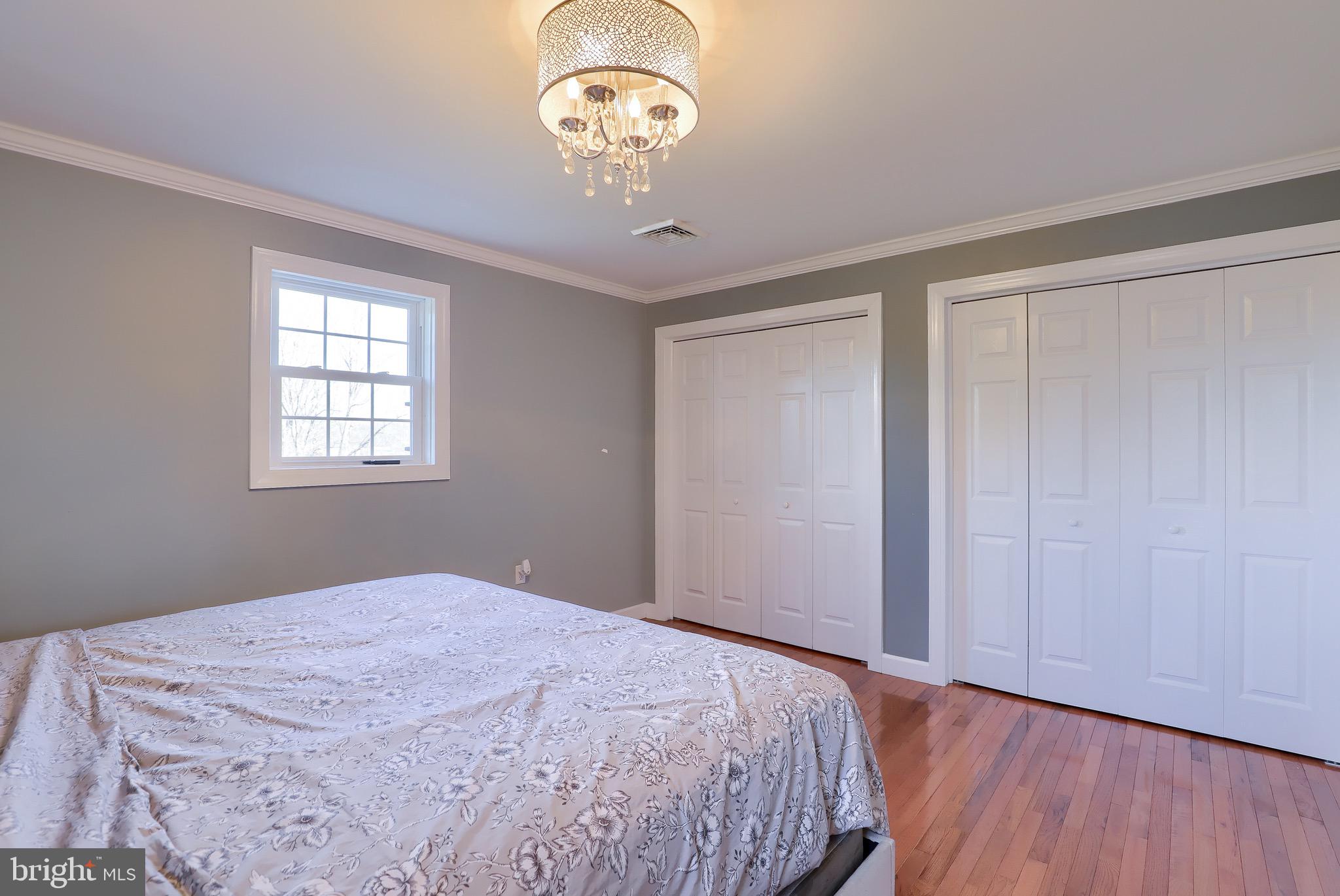 540 Blue Lake Road Denver, PA 17517 - Photo 49 of 63 a bedroom with a large bed and a chandelier