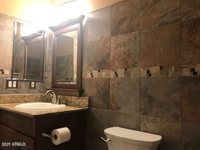 a bathroom with a sink a toilet and a mirror
